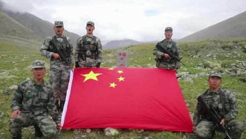 牧民手举国旗策马奔腾 身后是鹅卵石砌成的巨型国旗